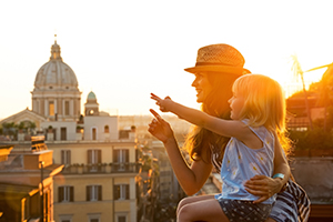 You spend money in different ways for different needs every day. mother holding her child and pointing at an object outside